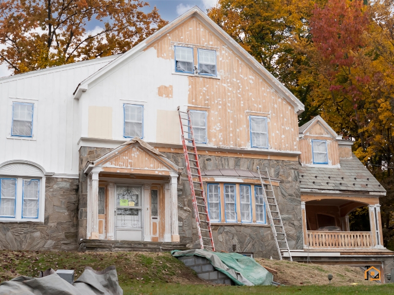 Elewacja domu w trakcie odnawiania i malowania z użyciem rusztowań