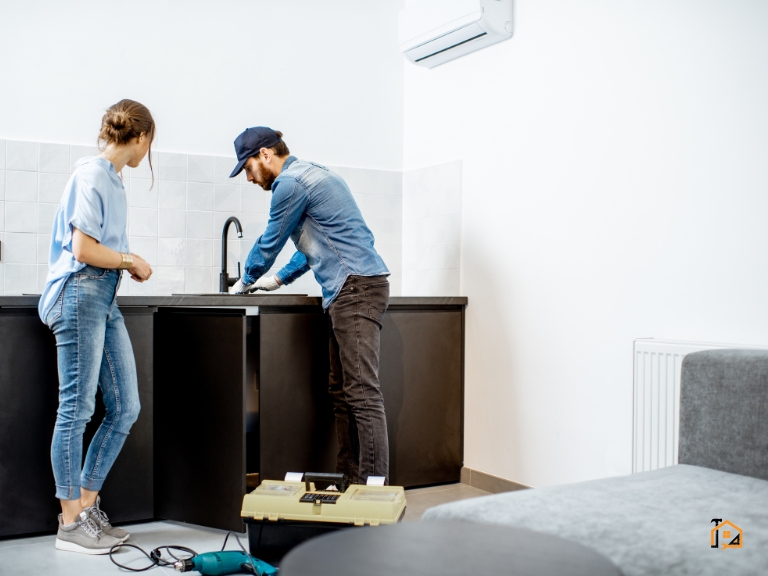 Para montująca baterię kuchenną przy zlewie w nowym mieszkaniu