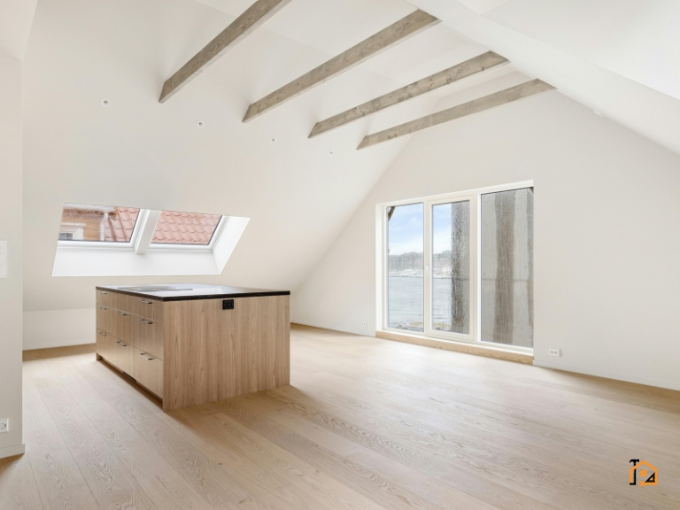 Jasne poddasze po remoncie z widocznymi belkami stropowymi